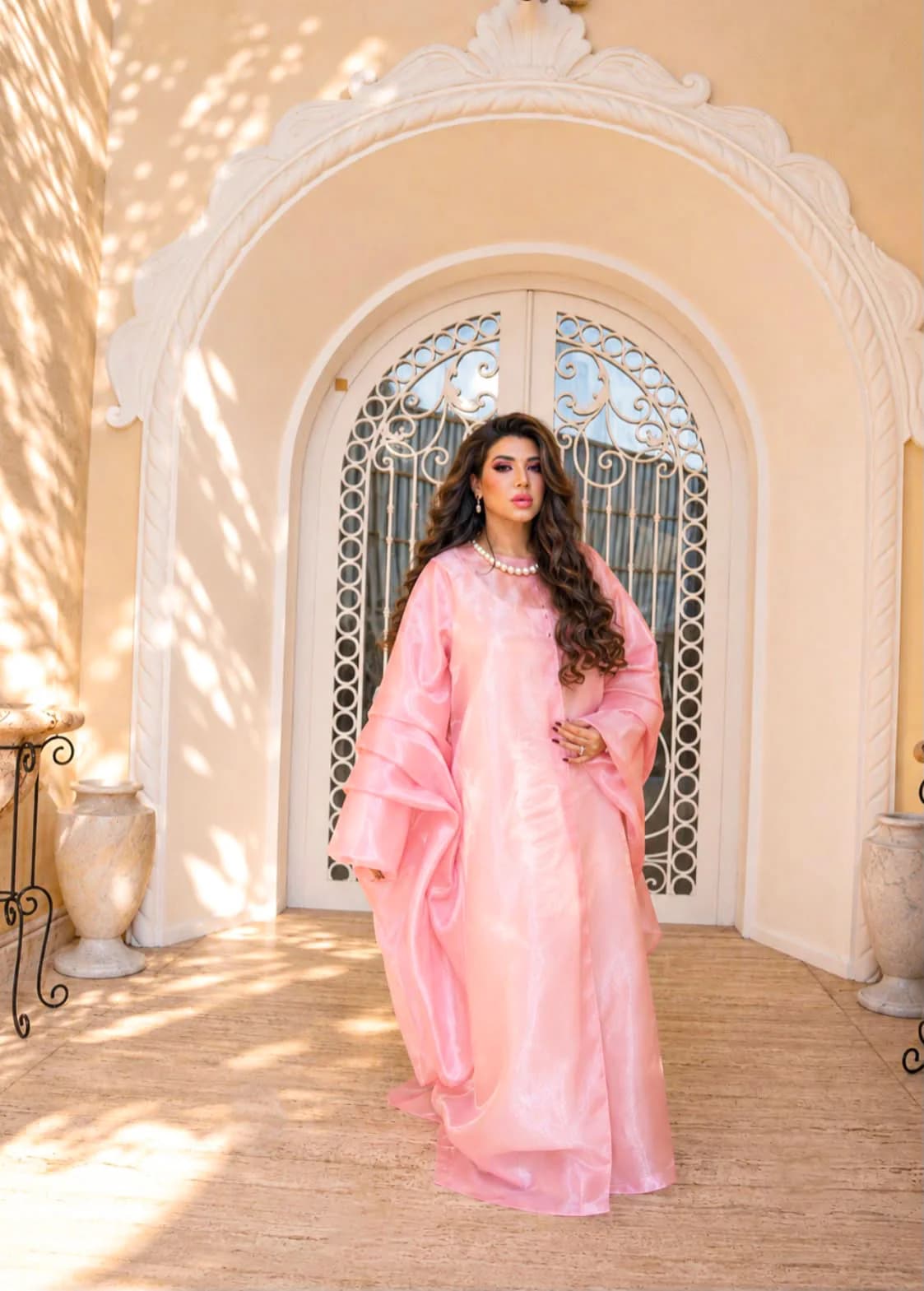Almas Anfar Kathuria standing in a pink doorway